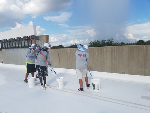 Revival Roofing Crew Rolling The Mastic On The Roofing Seams